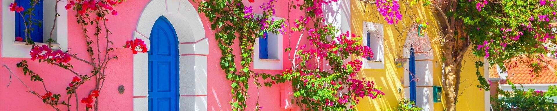 Roze en geel gekleurde huisjes op Kefalonia, Griekenland