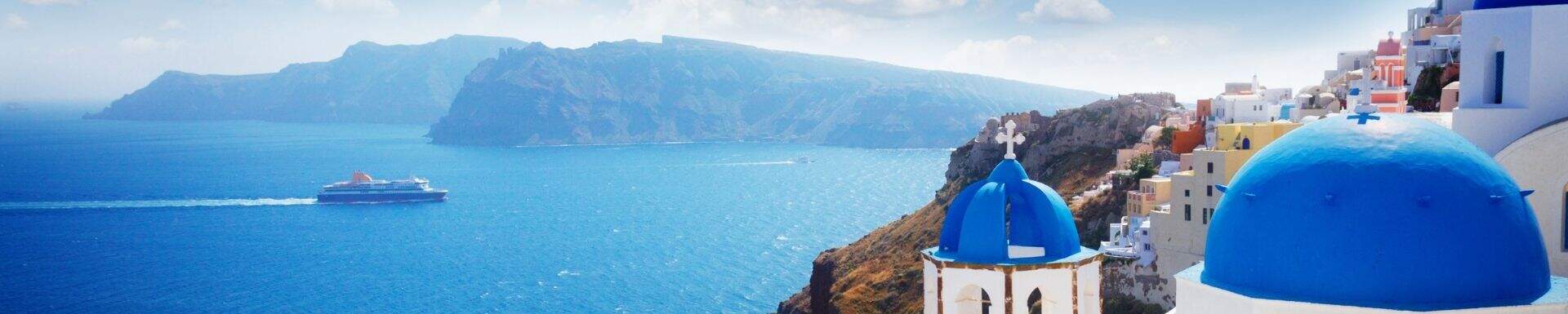 Witte huisjes met blauwe daken uitkijkend over de zee, op Santorini, Griekenland