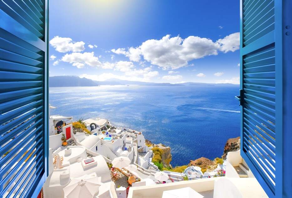 Doorkijkje door een raam met blauwe shutters op Santorini, Griekenland