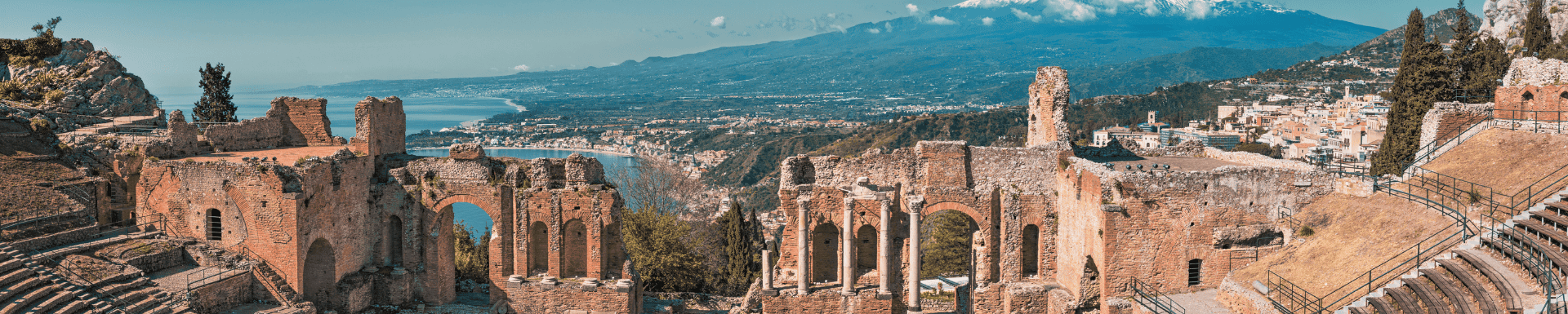 Ruïnes van het oude Griekse theater in Taormina met op de achtergrond de vulkaan Etna, Italië.