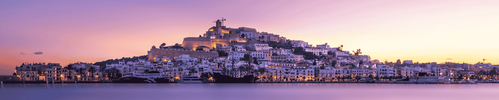Skyline van Ibiza met een roze/paarse lucht