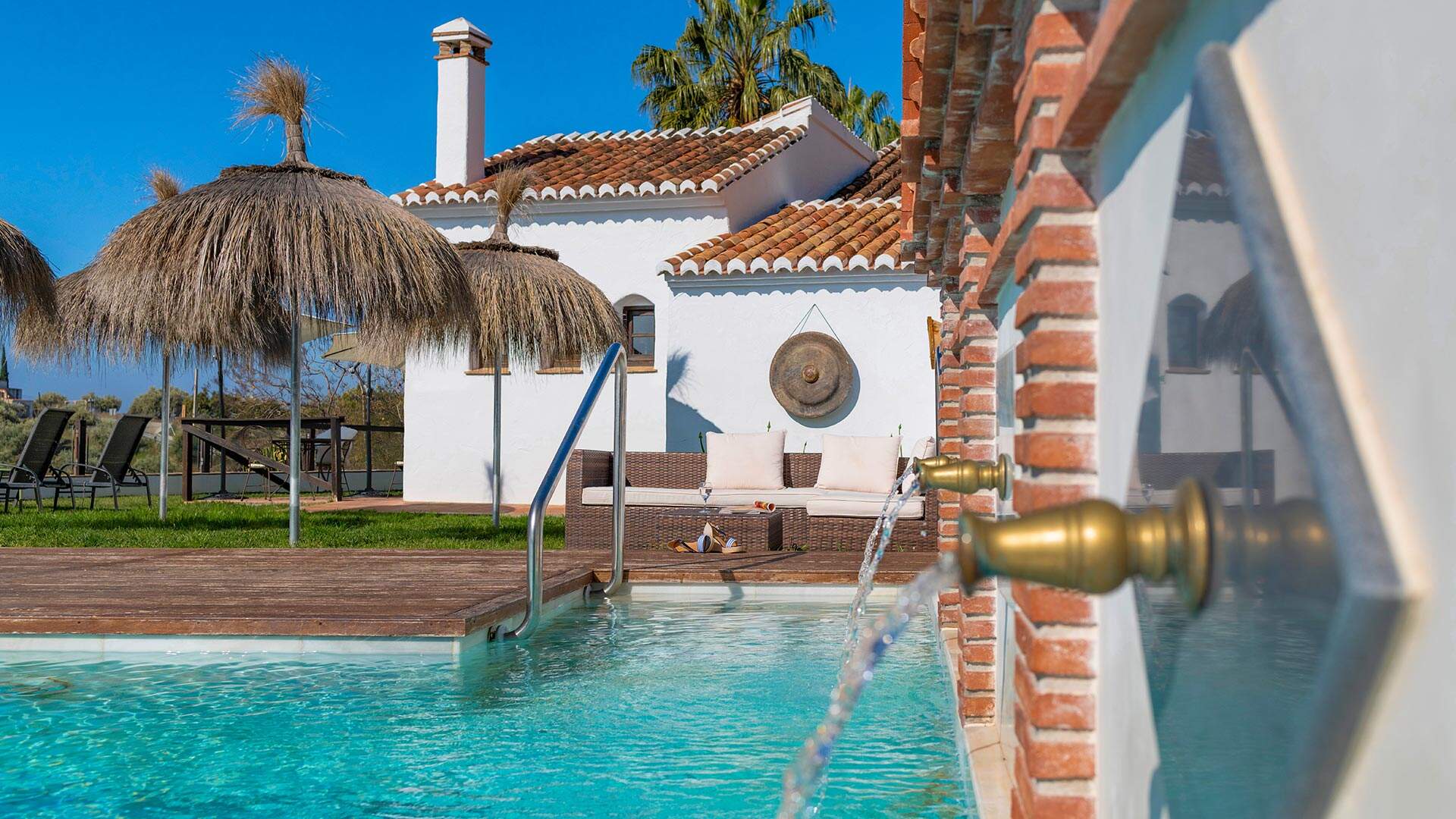 witte villas met zwembad en rieten parasols