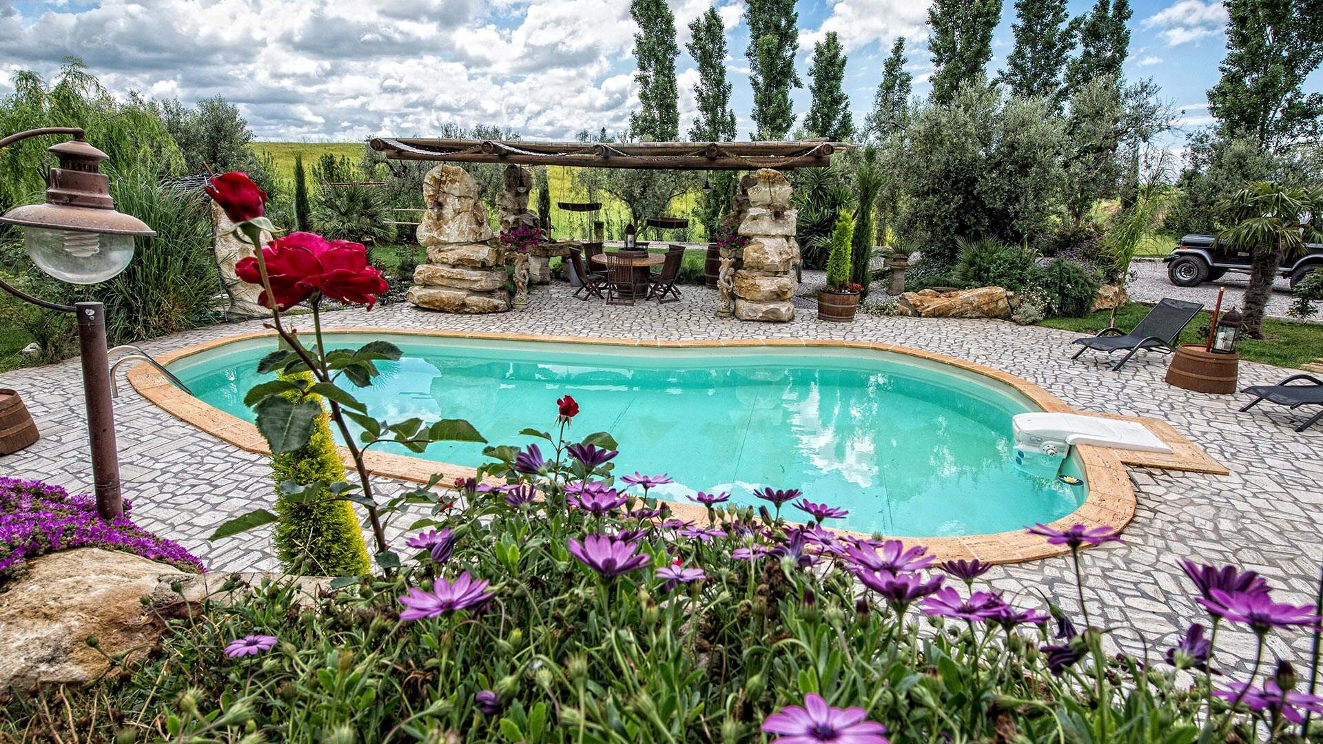 Zwembad met bloemen bij bed en breakfast in italie